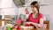 Young adult woman cuts a tomato for a vegetable salad