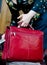 Young adult woman holds red leather laptop bag