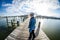 Young adult woman with long blonde hair whips her hair as she turns around on a seaside dock in Maryland