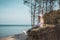 Young adult woman in pink hat sitting alone on the bluffs, looking of sea, freedom concept, peaceful atmosphere