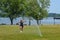 Young adult woman runs through the sprinklers in the park in the summer. Concept for carefree living