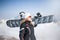 Young adult woman snowboarder holding snow board