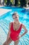 Young adult woman in swimsuit standing in pool