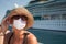 Young Adult Woman Wearing a Face Mask on Tender Boat With Passenger Cruise Ship Behind
