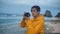 Young adventure photographer taking photographs on beautiful tropical beach