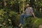 Young adventurer sitting on a trunk enjoying nature