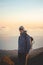 Young adventurer standing on the edge of a rock on the highest mountain Pico Ruivo on the island of Madeira, Portugal at sunrise.