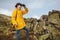 Young adventurous tourist reached the summit of mountains and using binoculars