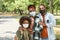 Young affectionate African family in masks standing in park