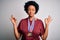 Young African American afro athlete woman with curly hair wearing medals for competition relax and smiling with eyes closed doing