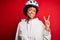 Young African American afro cyciling woman with curly hair wearing bike security helmet smiling with happy face winking at the