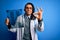 Young african american afro doctor man with dreadlocks holding chest lung xray doing ok sign with fingers, excellent symbol