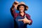 Young African American afro farmer woman with curly hair wearing apron and hat smiling making frame with hands and fingers with