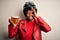 Young African American afro motorcyclist woman with curly hair drinking jar of beer with happy face smiling doing ok sign with
