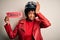 Young African American afro motorcyclist woman with curly hair holding danger paper message stressed with hand on head, shocked