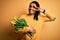 Young african american afro romantic man with dreadlocks holding bouquet of yellow tulips Doing peace symbol with fingers over