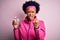 Young African American afro sportswoman with curly hair drinking glass of water annoyed and frustrated shouting with anger, crazy