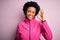 Young African American afro sportswoman with curly hair wearing sportswear doin sport smiling positive doing ok sign with hand and