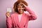 Young African American afro woman with curly hair holding papaer with tax day message with happy face smiling doing ok sign with