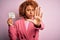 Young African American afro woman with curly hair holding papaer with tax day message with open hand doing stop sign with serious