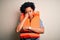 Young African American afro woman with curly hair wearing orange protection lifejacket thinking looking tired and bored with