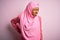 Young African American afro woman wearing muslim hijab over isolated pink background Suffering of backache, touching back with