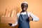 Young african american baker man wearing apron holding wooden box with homemade bread happy with big smile doing ok sign, thumb up
