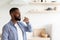 Young african american bearded male with closed eyes drinks water from glass