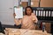 Young african american with braids working at small business ecommerce showing clipboard with open hand doing stop sign with