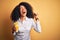 Young african american business woman with afro hair drinking coffee from take away cup screaming proud and celebrating victory