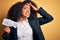 Young african american business woman with afro hair holding help paper for work stress stressed with hand on head, shocked with