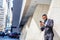 Young African American Businessman with beard, short hair, texting on cell phone outside in New York City