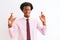 Young african american businessman wearing tie standing over isolated white background gesturing finger crossed smiling with hope