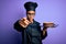 Young african american cooker girl wearing uniform and hat holding tray with cake pointing with finger to the camera and to you,