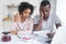 Young African-American couple at kitchen, husband holding bank notification