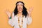 Young african american curly hippie woman wearing sunglasses and vintage accessories celebrating crazy and amazed for success with