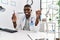 Young african american doctor man holding electronic cigarette at medical clinic smiling happy pointing with hand and finger to