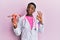 Young african american doctor woman holding anatomical model of female genital organ doing ok sign with fingers, smiling friendly