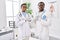 Young african american doctors working at medical clinic smiling with hands on chest with closed eyes and grateful gesture on face