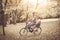 Young African American father driving his little daughter on bike trough park.