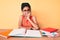 Young african american girl child with braids studying for school exam looking stressed and nervous with hands on mouth biting