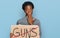 Young african american girl holding no guns warning banner covering mouth with hand, shocked and afraid for mistake