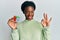 Young african american girl playing colorful puzzle cube intelligence game doing ok sign with fingers, smiling friendly gesturing