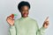 Young african american girl playing colorful puzzle cube intelligence game smiling happy pointing with hand and finger to the side