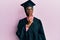 Young african american girl wearing graduation cap and ceremony robe thinking concentrated about doubt with finger on chin and