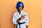 Young african american girl wearing taekwondo kimono and protection helmet smiling cheerful pointing with hand and finger up to