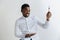 Young african american guy holding empty dish and fork with disgusting facial expression isolated on grey background