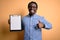 Young african american inspector man wearing glasses holding clipboard checklist happy with big smile doing ok sign, thumb up with