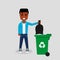 Young African American in jeans and sweatshirt throwing a black trash bag in a green recycle bin.