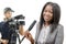 Young African american journalist with a microphone and a camera